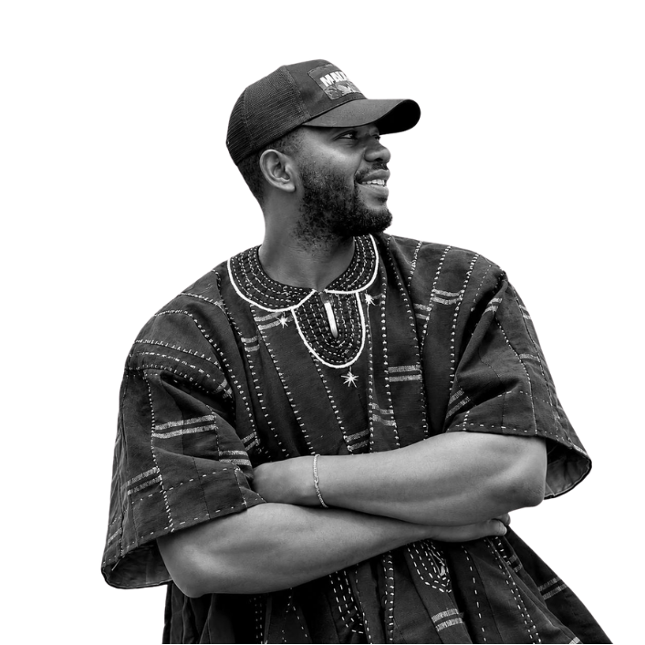 Suleman Mamuda, founder of Build44, in a black and white portrait wearing a cap and a traditional embroidered smock
