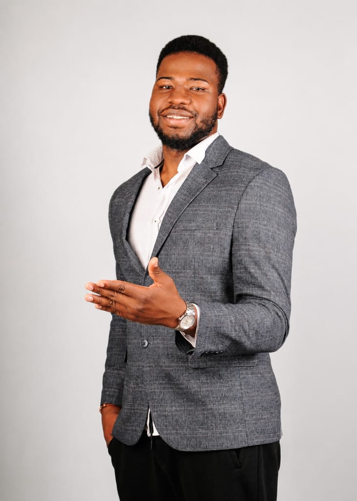 Suleman Mamuda in a grey blazer, smiling